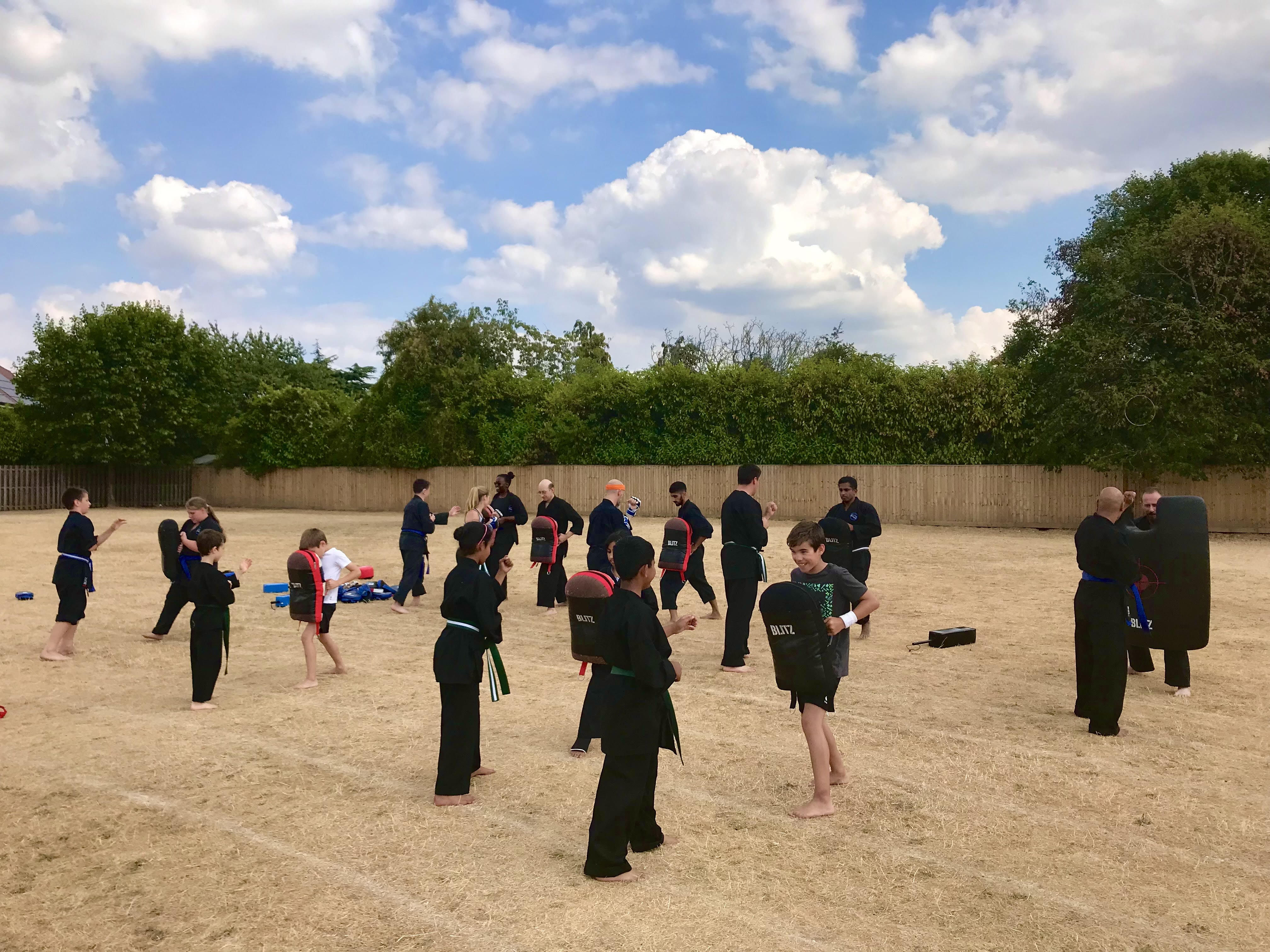Family martial arts training session in Maidenhead with parents and children practicing karate techniques together at Shuhari Self Defence dojo