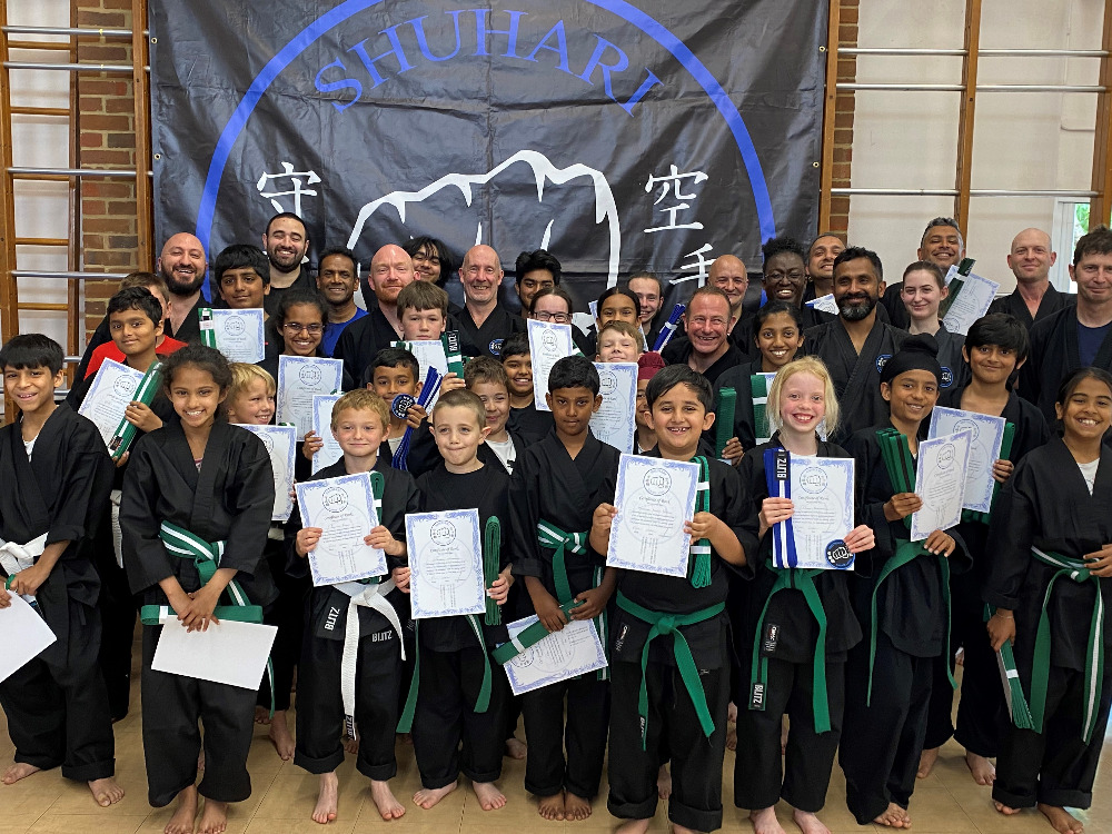 Children practicing martial arts confidence building exercises in group training session