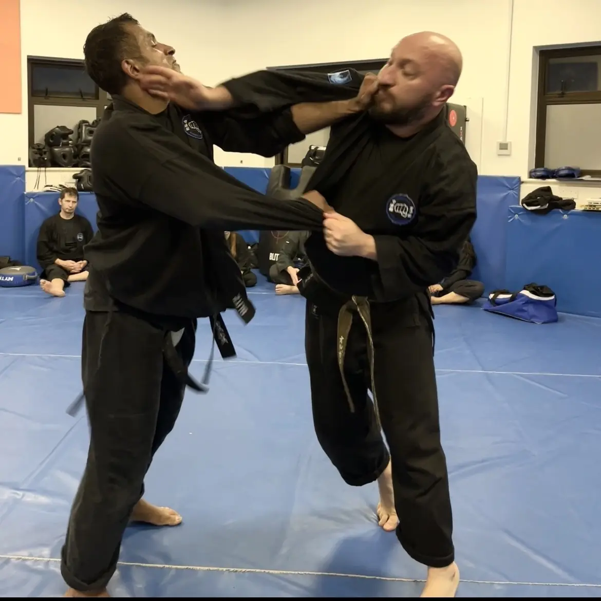 John Moses of Shuhari Self Defence Bracknell learning vertical grappling from Olgun Tiltay in a martial arts class John Moses of Shuhari Self Defence Bracknell learning vertical grappling from Olgun Tiltay in a martial arts class